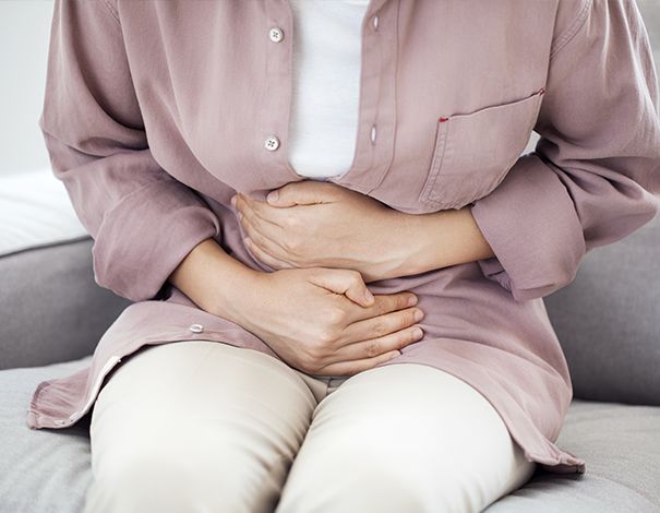 Woman holding her stomach - Constipation