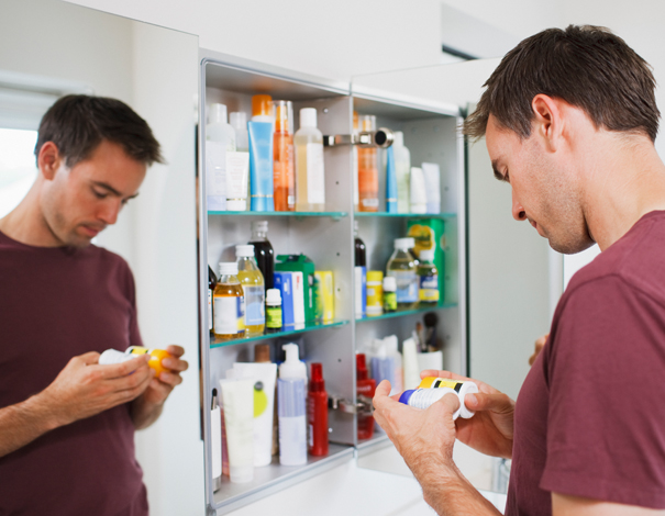 man looking in his medicine cabinet