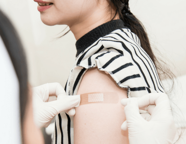 girl getting flu shot on arm