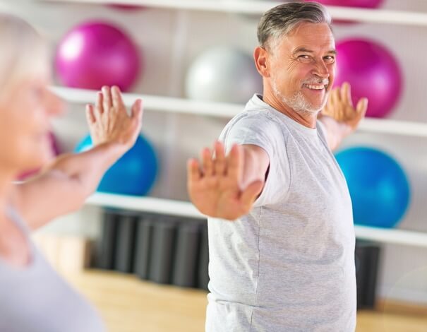 Senior man exercising in a class to improve his diabetes Senior man exercising in a class