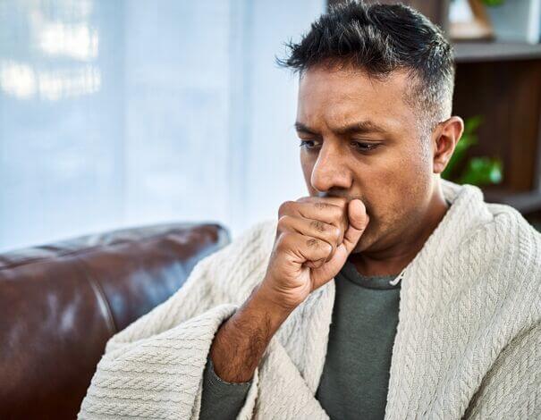 Man coughing in his hand as he is having pneumonia Man coughing in his hand