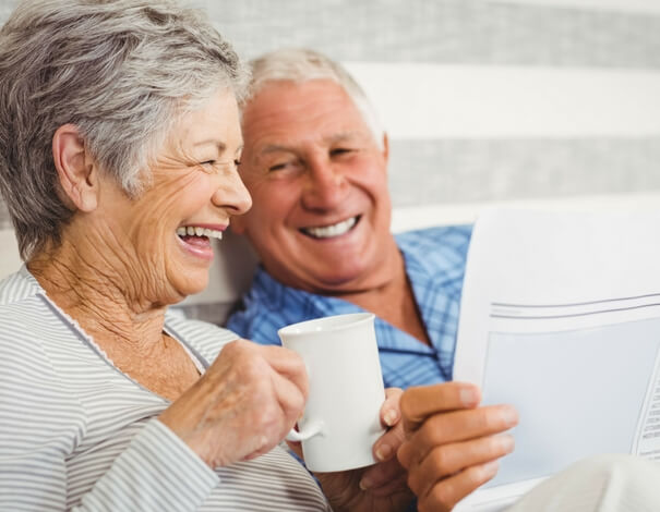 Senior couple laughing together while taking coffee Senior couple laughing together