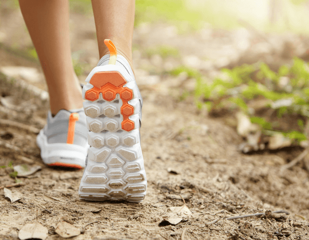 Women's feet wearing sports shoes in the woods