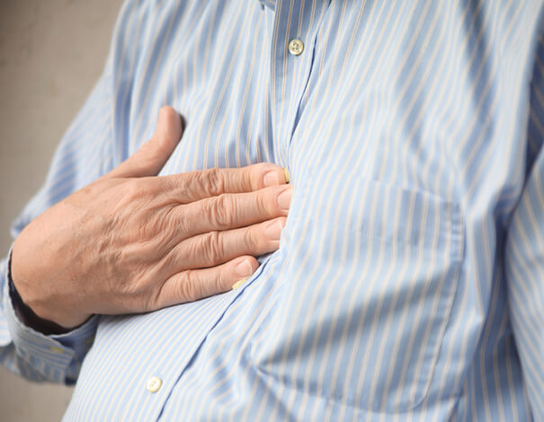 Person putting their hand on their chest because of acid reflux